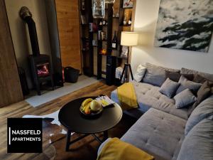 a living room with a couch and a table at Haus Anja NASSFELD APARTMENTS in Sonnenalpe Nassfeld