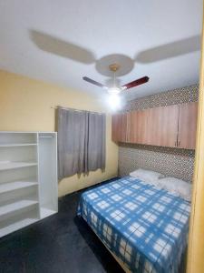 1 dormitorio con ventilador de techo y 1 cama en kitnet Aconchegante com simplicidade, en Ubatuba