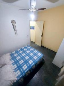 1 dormitorio con 1 cama y ventilador de techo en kitnet Aconchegante com simplicidade, en Ubatuba