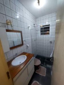 y baño con lavabo y espejo. en kitnet Aconchegante com simplicidade, en Ubatuba