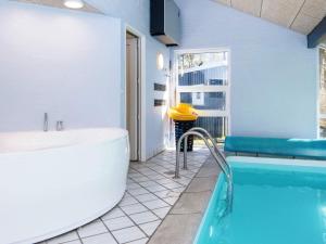 a large bathroom with a tub and a sink at 12 person holiday home in Glesborg in Glesborg