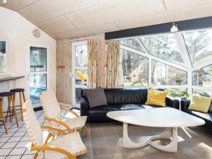 a living room with a couch and a table and chairs at 12 person holiday home in Glesborg in Glesborg