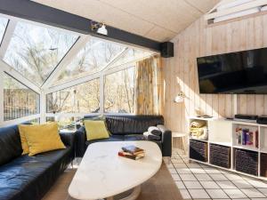 a living room with a couch and a table at 12 person holiday home in Glesborg in Glesborg