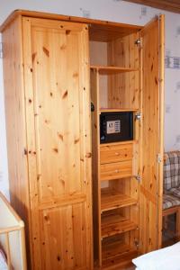 a wooden cabinet with a microwave inside of it at Bei Angela in Ladelund