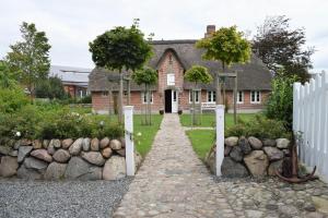 uma casa de tijolos com uma cerca branca em frente em Haus Frieda / Aventoft em Aventoft