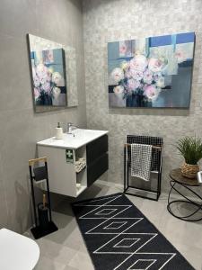 ein Badezimmer mit einem Waschbecken und einem Blumengemälde in der Unterkunft Art Sunset Luxuary Villa in Ribeira Brava
