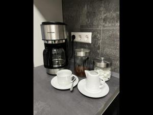 a counter with two cups and a coffee maker at NEU! Ferienwohnung Feuergasse 