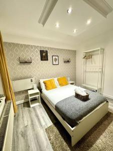 ein Schlafzimmer mit einem Bett mit gelben Kissen darauf in der Unterkunft Centrally-Located Gem in Marble Arch, London in London