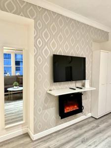 ein Wohnzimmer mit einem TV und einem Kamin in der Unterkunft Centrally-Located Gem in Marble Arch, London in London