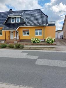 a yellow house with flowers in front of it at Moderne FeWo Seeidyll 3 Seen 2 Boote in Demen