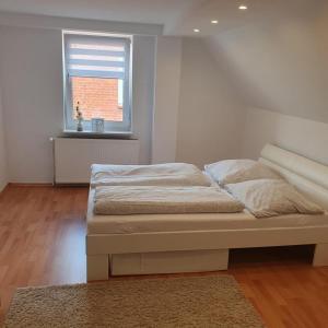 a bed in a white room with a window at Moderne FeWo Seeidyll 3 Seen 2 Boote in Demen