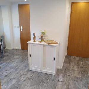 a white cabinet with a book on it in a room at Moderne FeWo Seeidyll 3 Seen 2 Boote in Demen +19 photos