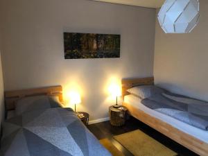 two twin beds in a room with two lamps at NEU! Moderne FeWo Georgsmarienhütte in Georgsmarienhütte