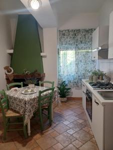 uma cozinha com uma mesa e uma parede verde em Casa Vacanza Io e Te em San Marco Argentano