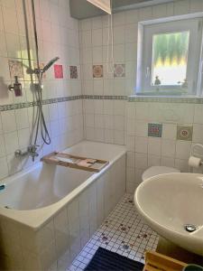 a bathroom with a tub and a sink at NEU! Ferienwohnung Milo Pfälzer Wald in Rodalben +8 photos