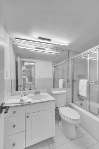 y baño con aseo, lavabo y ducha. en Cozy Ocean View Condo Beach Service 1015, en Miami Beach