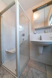 a bathroom with a glass shower and a sink at NEU! Ferienwohnung Am Mühlberg in Selters