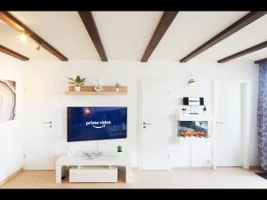 een woonkamer met een tv aan een witte muur bij NEU! FeWo Panoramablick Hohegeiß Pool und Sauna in Hohegeiß
