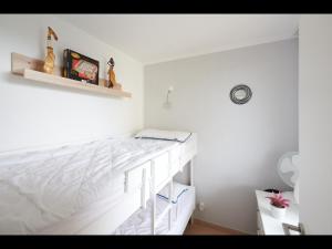 een witte slaapkamer met een bed en planken bij NEU! FeWo Panoramablick Hohegeiß Pool und Sauna in Hohegeiß