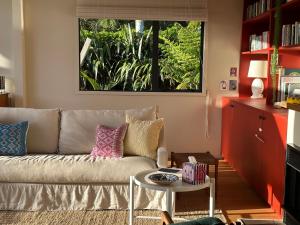 a living room with a couch and a table at The Driving Creek Cottage in Coromandel Town