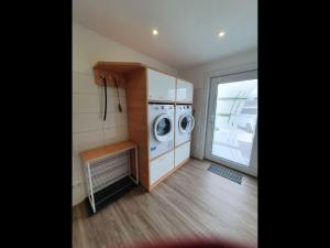 a laundry room with a washer and dryer in it at NEU! Ferienhaus 54 Husum inkl Sauna in Husum
