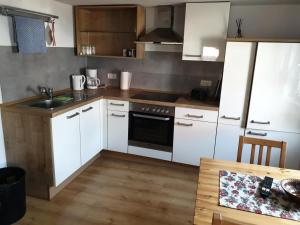 cocina con electrodomésticos blancos y suelo de madera en NEU! Ferienhaus Michelsberg, 
