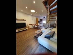 ein Wohnzimmer mit einem Sofa und einer Treppe in der Unterkunft NEU! Ferienhaus 54 Husum inkl Sauna in Husum