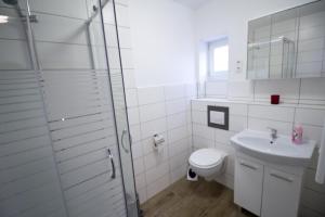 uma casa de banho branca com um WC e um lavatório em Liebevoll eingerichtete FeWo Alsfeld 2 em Alsfeld