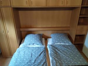 two beds in a cabinet with blue sheets at NEU! Sommerhaus im Cuxland in Hechthausen