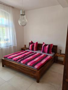 1 dormitorio con 1 cama grande con almohadas rojas y negras en NEU! Ferienwohnung in Mücheln mit Balkon en Mücheln