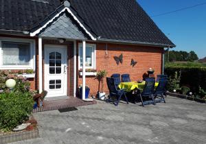 un patio con mesa y sillas frente a una casa en NEU! Ferienwohnung Luna zwischen den Meeren, en Ihlow