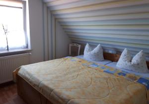 1 dormitorio con 1 cama grande con almohadas blancas en NEU! Ferienwohnung Luna zwischen den Meeren, en Ihlow