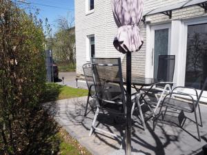 a table and chairs with a umbrella on a patio at FeWo Westerwaelder Höhenluft in Langenbach bei Kirburg