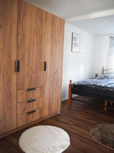 FeWo Westerwaelder Höhenluft في Langenbach bei Kirburg: غرفة نوم مع خزانة خشبية كبيرة وسرير
