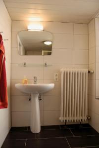 a bathroom with a sink and a radiator at NEU! Ferienhaus Johann an der Nordsee in Dornum