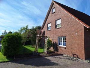 una casa de ladrillo con una puerta delante de ella en NEU! Ferienhaus Wattentraum mit Sauna, en Dornum