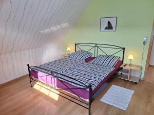 1 dormitorio con 1 cama grande con sábanas moradas en NEU! Ferienhaus Wattentraum mit Sauna, en Dornum