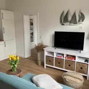sala de estar con TV y sofá azul en NEU Küstenliebe Friesland, en Varel