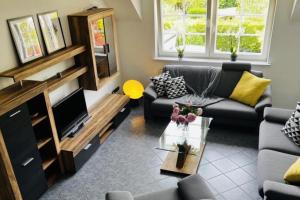 - un salon avec un canapé et une télévision dans l'établissement Modernes Ferienhaus Sauerblick, à Langsur