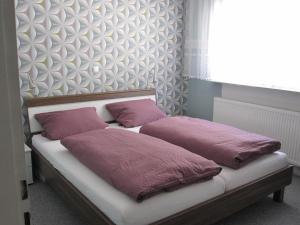 a bed with two purple pillows on top of it at Ferienhaus am Rheinsteig in Kaub