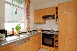 cocina con armarios de madera, fregadero y ventana en NEU! Ostseeperle Zinnnowitz, en Zinnowitz