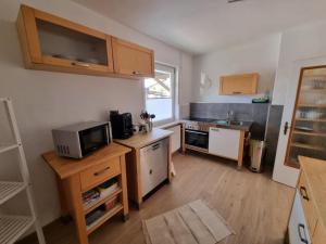 a small kitchen with a microwave and a stove at Ferienhaus Am Zollhaus in Teplingen