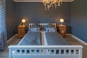 a bedroom with two beds and two lamps and a chandelier at NEU! Exklusives Ferienhaus Ella in Dornum