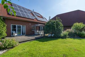 a house with solar panels on the roof at NEU! Exklusives Ferienhaus Ella in Dornum