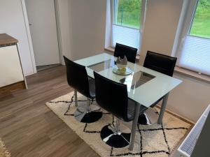 ein Esszimmer mit einem Glastisch und schwarzen Stühlen in der Unterkunft NEU Ferienwohnung MONTE in Walsrode in Walsrode