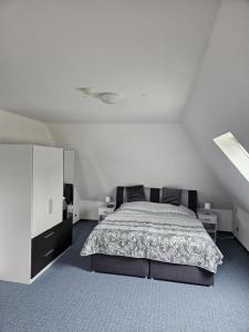 a bedroom with a bed and a white wall at NEU! Ferienwohnung zum Anker in Heeslingen