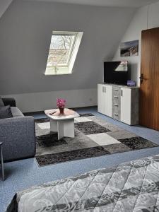 a room with a bed and a table and a tv at NEU! Ferienwohnung zum Anker in Heeslingen