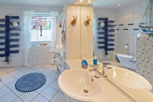 a bathroom with a sink and a tub and a toilet at NEU! Exklusives Ferienhaus Ella in Dornum +33 photos