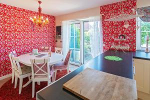 a kitchen with a table and a dining room with red walls at NEU! Exklusives Ferienhaus Ella in Dornum