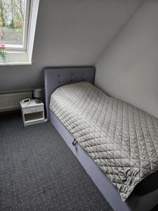 a small bed in a room with a window at NEU! Ferienwohnung zum Anker in Heeslingen